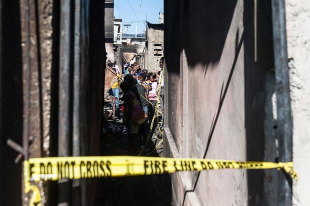 Curiosos permanecen en el lugar de una explosión hoy, en Cap Haitian, Haití.
