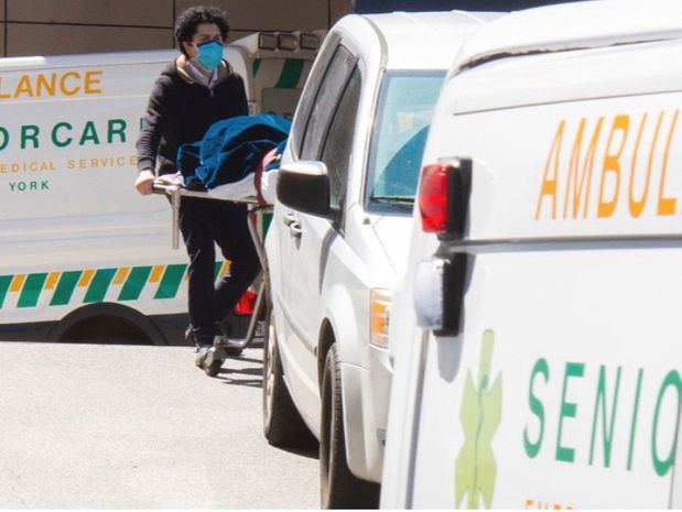 Trabajadores de salud en un hospital de Nueva York trasladan a un paciente muerto a causa del COVID-19.