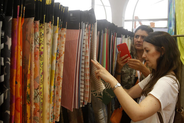 Un par de mujeres fue registrado este martes, 24 de enero, al detallar muestras de telas, durante el primer día de la edición 35 de Colombiatex, en Medellín, Colombia.