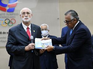 Luis Mejía Oviedo, derecha, entrega el libro de los estatutos del COD y la Carta Olímpica a Antonio Acosta, quien asume la presidencia del organismo olímpico.