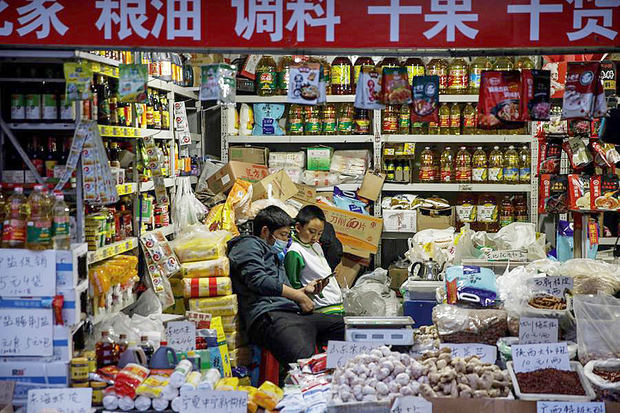 Un hombre junto a un niño en su puesto de un mercado en Pekín, China, el 20 de octubre de 2020.