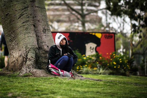 Una mujer descansa frente a un mural de Mafalda hoy, jueves en Buenos Aires. Argentina.