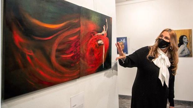 La pintora dominicana Jeannette Alfau ante su retrato de la bailarina cubana Alicia Alonso, en su exposición 'Heroínas de América' en la ciudad española de Logroño.