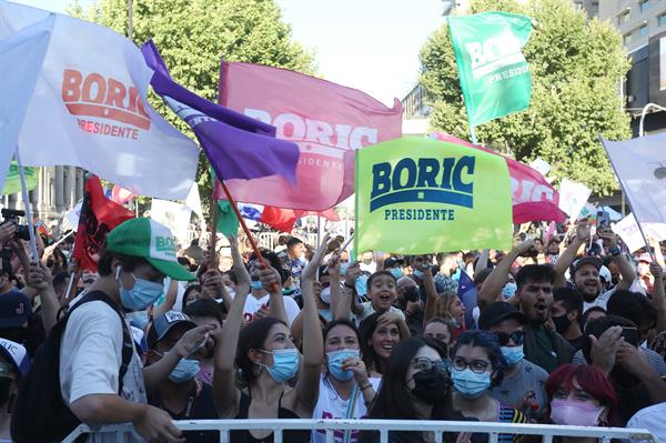 Personas reaccionan al triunfo del candidato presidencial Gabriel Boric, hoy en Santiago (Chile). 