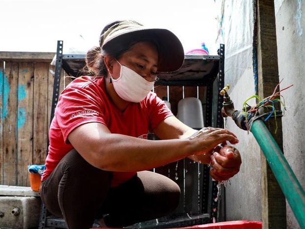 Una mujer habitante del barrio 'Los Jazmines' se lava las manos, el 31 de marzo de 2020, en el distrito de Comas, Perú.
