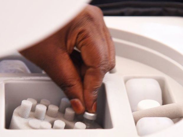 Un trabajador sanitario recoge un vial de la vacuna COVID-19 de AstraZeneca de un recipiente refrigerado en Uganda.