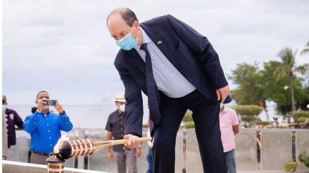 Embajador Biran encendiendo una antorcha.