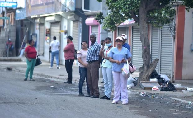 Varias personas esperan transporte público durante el paro convocado en protesta por las políticas económicas del Gobierno, hoy en Santiago, República Dominicana.