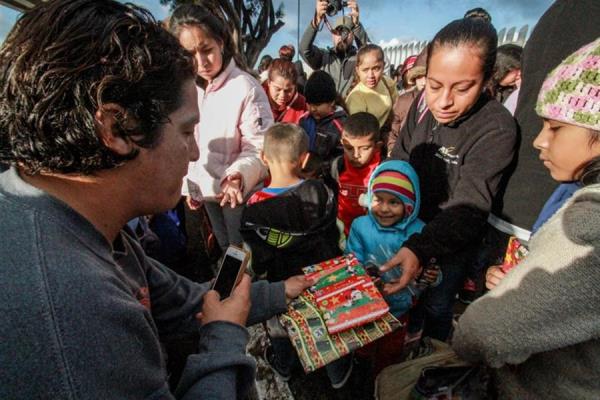 Personas de la ciudad de Tijuana, en el estado de Baja California, reparten un poco de comida a migrantes estacionados en esta zona fronteriza de México. 