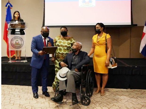 Embajador Smith Augustin entrega placa de reconocimiento al artista haitiano Cédon.