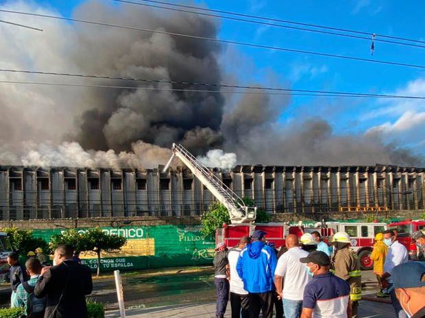 Bomberos sofocan el incendio en el almacén.