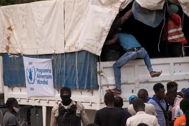 Un empleado sube a una camión del Programa Mundial de Alimentos para repartir comida a los damnificados del terremoto, este viernes en Camp Perrin, Haití.
