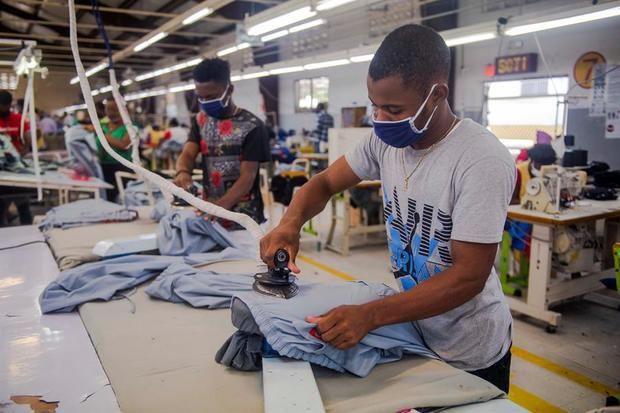 Decenas de trabajadores confeccionan mascarillas y vestuario médico este martes, en el Parque Industrial SONAPI, en Puerto Príncipe, Haití. 