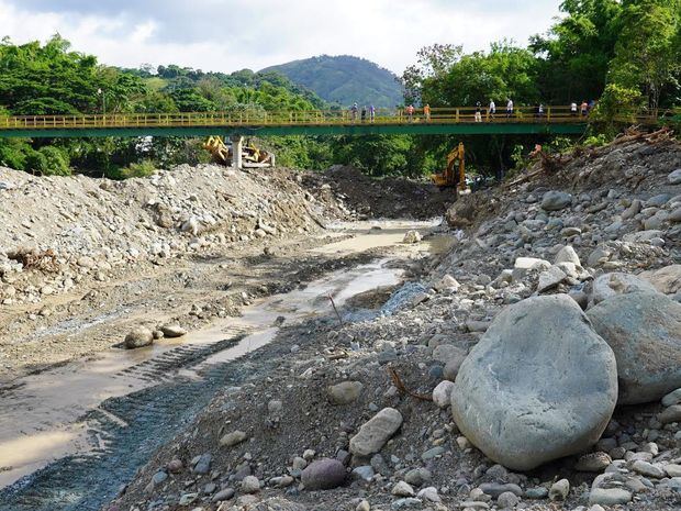 Equipos pesados trabajan en la canalización del río para construir el muro en la margen derecha.