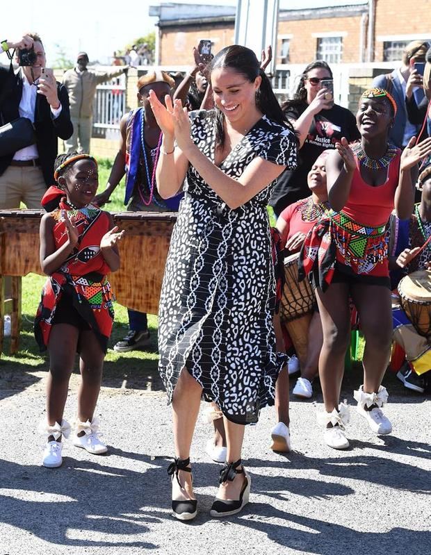 La duquesa de Sussex durante un viaje a Sudafrica lució un vestido estampado en negro y blanco con línea 'wrap'. 