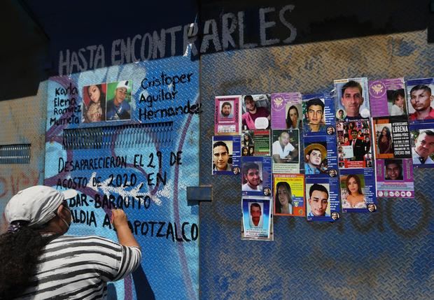 Madres y familiares de personas desaparecidas colocan el 15 de mayo del 2022 imágenes de sus seres queridos en las vallas que rodean lo que fuera la Glorieta de la Palma, en Ciudad de México, México.