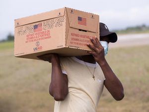Personal del Programa Mundial de Alimentos (WFP) de la ONU carga alimentos a un helicóptero de la organización para llevar a la ciudad de Jeremie, este jueves, desde Les Cayes, Haití.