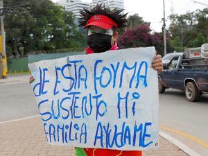 Una mujer vestida de payaso pide ayuda económica en una calle de Tegucigalpa, Honduras.