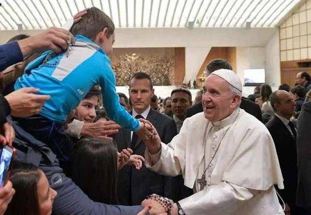 El papa Francisco saluda a un niño. 