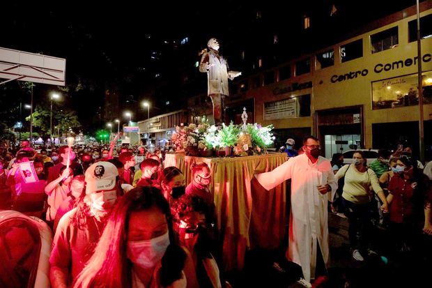 Miembros de la Iglesia junto a fieles llevan una reliquia y la imagen del beato venezolano José Gregorio Hernández durante una procesión para conmemorar su natalicio en Caracas, Venezuela.