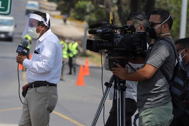 El periodista hondureño Víctor Rodríguez usa medidas de bioseguridad mientras informa en directo sobre la situación del avance del coronavirus.