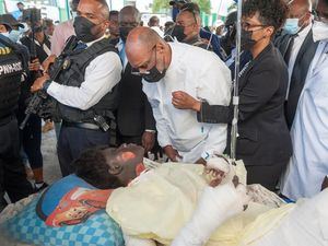 El primer ministro de Haití, Ariel Henry (c), visita a los heridos de una explosión hoy, en Cap Haitien, Haití.