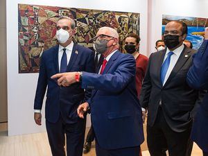 El presidente Luis Adinader observa la exposición de las imágenes del pintor Paul Giudicelli que ambientaron el salón donde Banreservas celebró el coctel en Madrid.