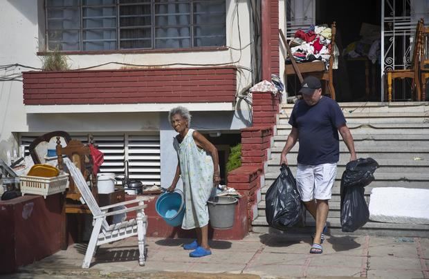 Varias personas sacan a la calles sus pertenencias tras el paso del huracán Ian, hoy en La Habana, Cuba.
