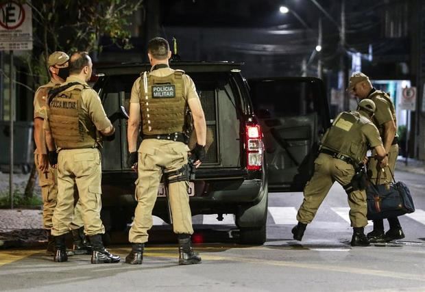 Miembros de la policía recogen el dinero que los asaltantes dejaron en la madrugada de este martes, en una de las calles en Criciuma. Miembros de la policía recogen el dinero que los asaltantes dejaron en la madrugada de este martes, en una de las calles en Criciuma.