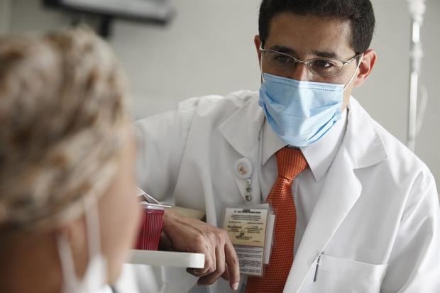 Fotografía cedida este jueves que muestra a un médico ofreciendo atención médica personalizada a un paciente.