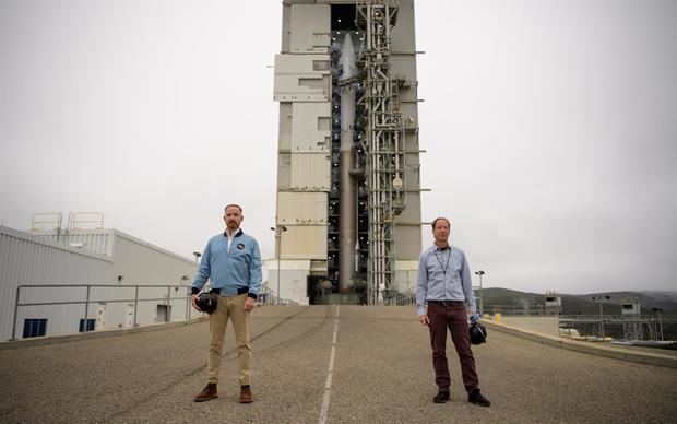 Fotografía cedida por la NASA que muestra al actor Marc Evan Jackson (i) y al científico Jeff Masek (d), junto a un cohete Atlas V el nuevo satélite del programa Landsat en la Base de la Fuerza Espacial Vandenberg (California), este 26 de septiembre de 2021.