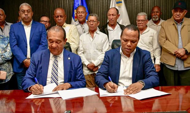 Momento en que Antonio Marte y Milton Morrison firmam del acuerdo.
