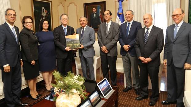 El señor Manuel A. Grullón, acompañado de los señores Inmaculada Adames, Frank Moya Pons, Ana Idalia Grullón y José Mármol, hace entrega del primer ejemplar del libro “La Sierra” al presidente de la República, licenciado Danilo Medina Sánchez, quien a su vez estuvo acompañado de los ministros Gustavo Montalvo, José Ramón Peralta y Francisco Domínguez Brito. En ese encuentro, sostenido en el Palacio Nacional, también se proyectó el video “El Rostro de la Sierra”, dirigido por Juan Basanta