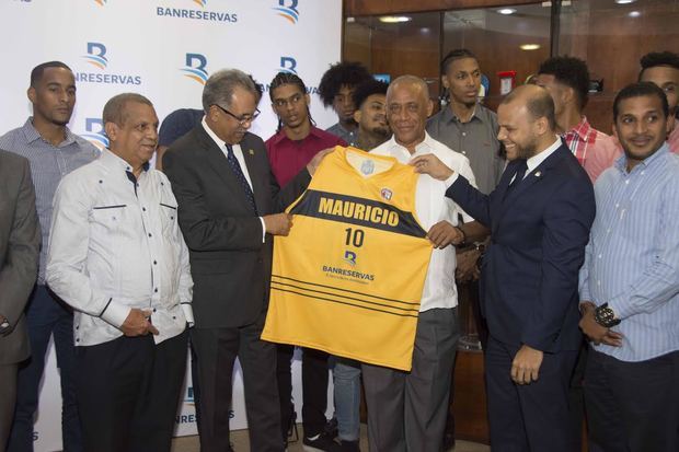 Leo Corporán y José Boyón Domínguez entregan camisetas del equipo al administrador general de Banreservas, Simón Lizardo Mézquita.