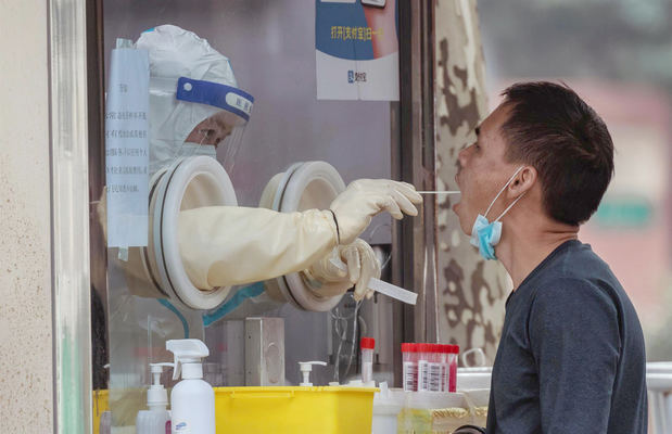 Un hombre se somete a una prueba de PCR de Coronavirus en un puesto de pruebas improvisado en Shanghai, China.