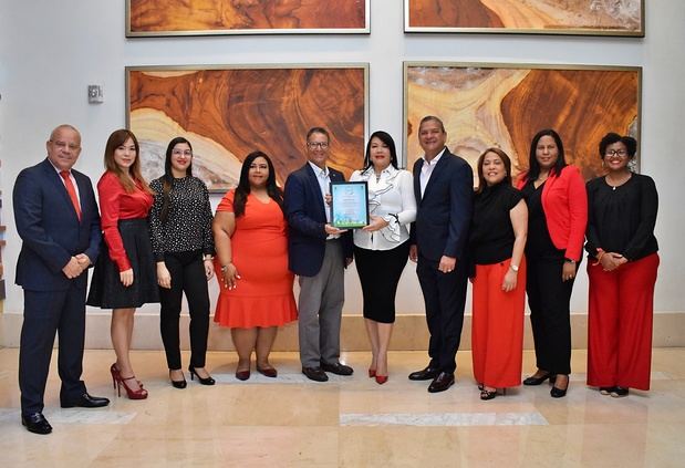 Al centro Nicolás Cáffaro entrega a Sulin Lantigua de Glass e Ignacio Glass el certificado a su lado ejecutivos y gerentes de la empresa Grabo Estilo.