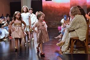 Niños modelando los diseños de Isabel Reynoso.