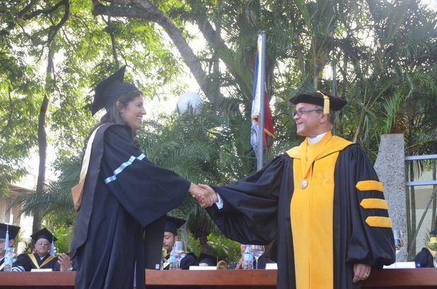 Graduanda y el Presbítero Dr. Alfredo de la Cruz Baldera, rector de PUCMM