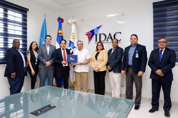 El director general Héctor Porcella y Carlos Barranco de AFP Crecer, junto a funcionarios del IDAC.