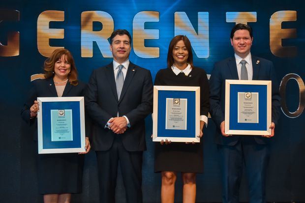 Los señores Zoila López, Karina Vallejo y Luis del Toro fueron premiados por la excelencia en el cumplimiento de las metas y los valores institucionales. Junto a ellos, en el centro, el señor Christopher Paniagua, presidente ejecutivo del Banco Popular Dominicano. 