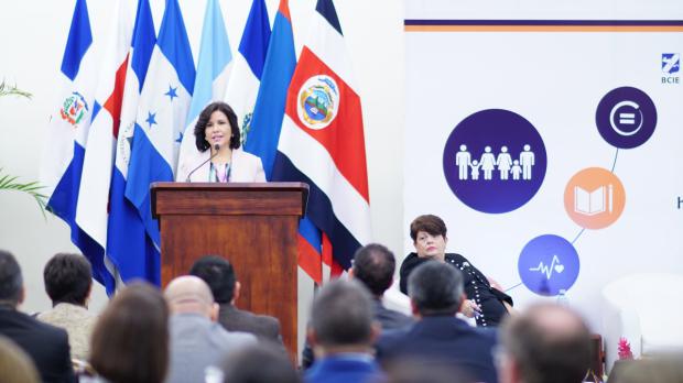 La directora de la BIJRD, Dulce Elvira de los Santos, entrega un ejemplar de la obra Diálogo con Juan Pablo Duarte escrita por la vicepresidenta de la República, Margarita Cedeño, a uno de los estudiantes participantes en el acto.  