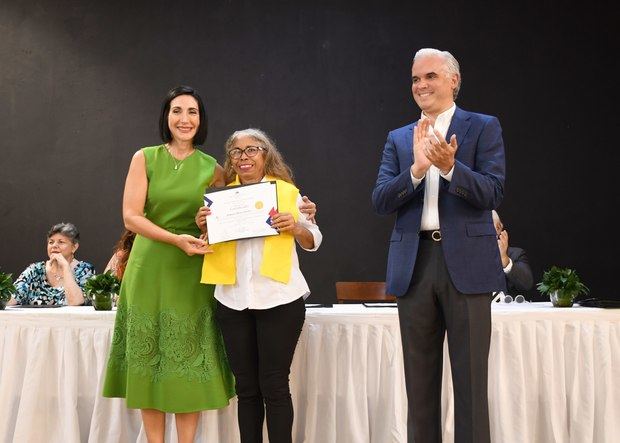 La primera dama, Raquel Arbaje y el ministro de Trabajo, Luis Miguel De Camps entregan diploma a la meritoria Altagracia Sánchez.