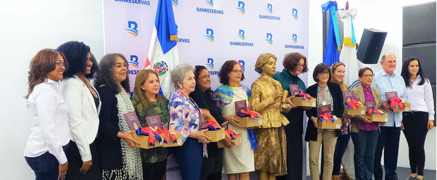 Las ponentes en el panel sobre Carmen Natalia, parientes de la escritora, la moderadora Ilonka Nacidid-Perdomo y una estatua viva, en la foto final del evento.