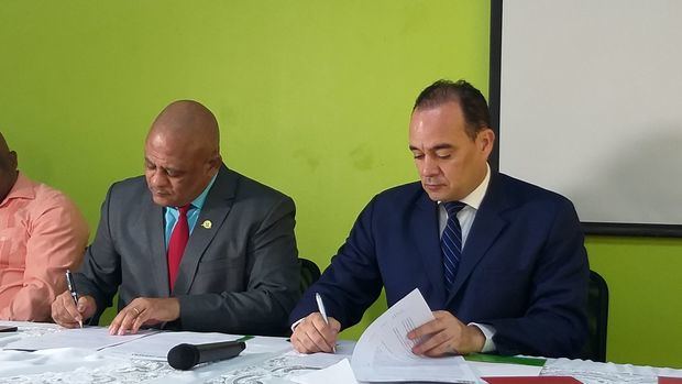 El licenciado Jorge Eligio Méndez Pérez y el doctor Miguel Surun Hernández, ejecutivos principales de COOPHERRERA y el Colegio de Abogados de RD, firman el acuerdo.