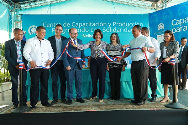 La vicepresidenta de la República, doctora Margarita Cedeño corta la cinta de inauguración del nuevo Centro de Capacitación y Producción Progresando con Solidaridad (CCPP) de Neiba, junto al alcalde Eliferbo Herazme; Héctor Medina, subdirector de Progresando con Solidaridad (Prosoli); Ernesto Prieto, coordinador de la Agencia Andaluza de Cooperación Internacional para el Desarrollo (AACID); Luis Mateos, ministro consejero y encargado de negocios de la embajada de España; la directora de Prosoli, Altragracia Suriel; Ángel Cuevas, párroco de la iglesia San Bartolomé de Neiba; Ezequiel Vólquez, director de Planificación de Prosoli; y la pastora Sobeida Ferreras, quien representó a la comunidad.