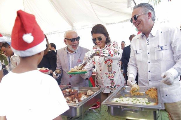 La vicepresidenta de la República, doctora Margarita Cedeño; y los comunicadores Jochy Santos y Roberto Cavada, sirven el almuerzo a parte de los 350 niños, niñas y adolescentes en situación de calle que disfrutaron este jueves el agasajo que la Vicepresidencia les ofreció con motivo de la Navidad.