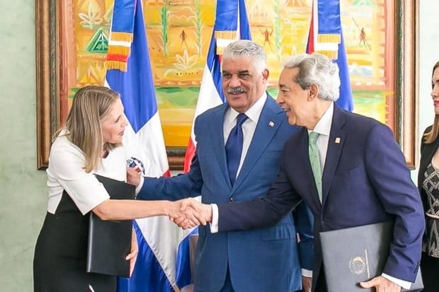 El presidente de Adoexpo, Luis Concepción y la decana del CC, Clara Reid, se saludan luego de firmar el acuerdo. Observa, el canciller Miguel Vargas.