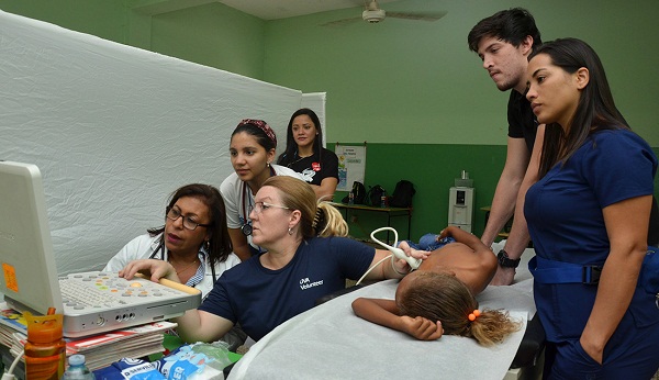 Dras Elaine Garrido y Kimberly Chadwell realizando procedimiento a niño en Neyba