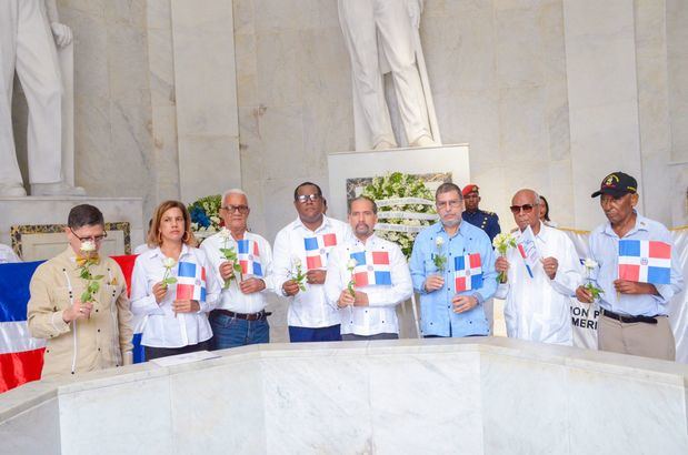 Representantes de las fundaciones patrióticas y colaboradores de Efemérides Patrias, antes de depositar una rosa en la llama votiva.