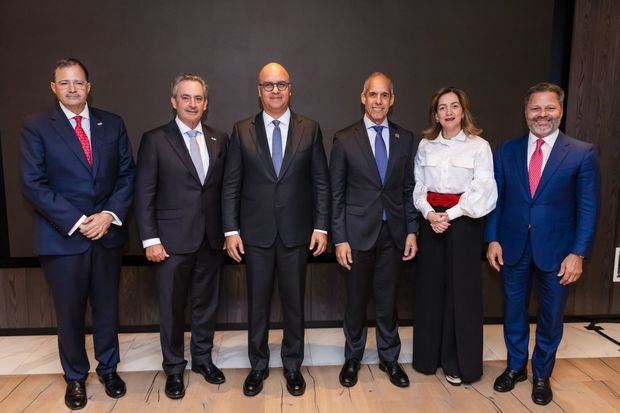 El director general del IDAC, Igor Rodríguez, (al centro); junto al comité ejecutivo de la Cámara Americana De Comercio de la República Dominicana (AMCHAMDR).